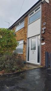 a brick house with a white garage door at Superb 4 Bed 4 Bath House Right by Luton Airport in Luton