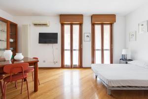 a bedroom with a bed and a desk and a tv at Cosy Studio with balcony & private garage in Milan