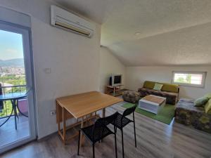 sala de estar con mesa, sillas y sofá en Sweet guesthouse en Mostar