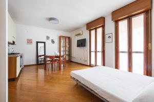 a bedroom with a bed and a kitchen and a table at Cosy Studio with balcony & private garage in Milan