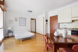 a kitchen and dining room with a table and a couch at Cosy Studio with balcony & private garage in Milan