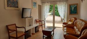 Una sala de estar con un sofá y sillas y un televisor. en Carestella, en Porto Vecchio