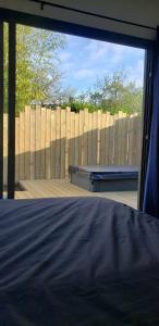 1 dormitorio con ventana grande y valla de madera en Studio de jardin au calme en Hennebont