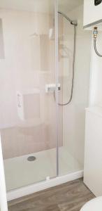 eine Dusche mit Glastür im Bad in der Unterkunft Studio de jardin au calme in Hennebont