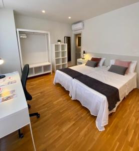 - une chambre avec un grand lit et un bureau dans l'établissement Casa centro Sabadell a 20Km BCN ideal Familias y Grupo Amigos, à Sabadell