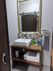 ein Bad mit einem Waschbecken und einem Spiegel in der Unterkunft Mossie Nes - Self Catering in Bloemfontein