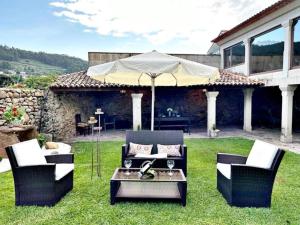 a patio with a table and chairs and an umbrella at Holibai, O Canizo, Retroceder En La Historia Y El Tiempo in Baiona