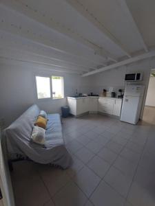 a large white kitchen with a couch in a room at Beau T2 Cosy tout Confort avec terrasse et jardin in Les Abymes