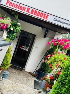 una entrada a un restaurante con flores en ollas en Pension K.Krause en Salzgitter