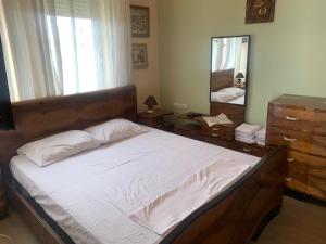 a bedroom with a large bed and a mirror at Lake View Apartment in Pogradec