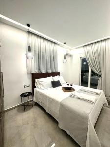 una camera da letto con un grande letto con lenzuola bianche di Flev's Luxury House with pool a Kremasti