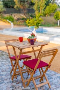 ein Holztisch und zwei Stühle mit Blumen drauf in der Unterkunft Yeşilçam Glamping in Çakırlar