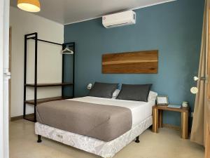 a bedroom with a bed and a blue wall at La Tica y La Gata in Puerto Viejo