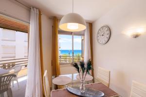 a dining room with a table and a clock on the wall at UHC Capote Family Apartments in Salou