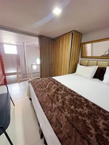 um quarto de hotel com uma cama e uma cadeira em Studio Bangalô Belém Hospedagem em Belém
