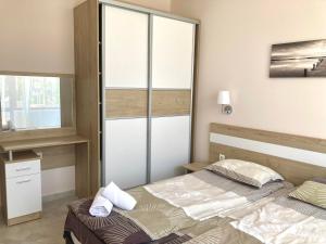 een slaapkamer met 2 bedden en een raam bij Apartments in Villas Apolon in Sozopol