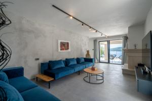 ein Wohnzimmer mit einem blauen Sofa und einem Tisch in der Unterkunft Villa Orizzonte in Sumartin