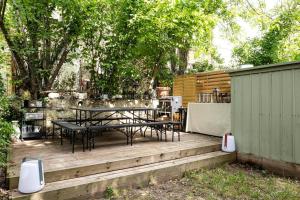 une terrasse en bois avec une table et des chaises. dans l'établissement Charmant Appartement avec Jardin, à Suresnes