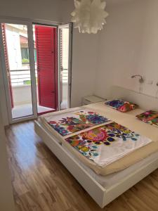 Vila Anda في بروماجنا: غرفة نوم مع سرير مع بطانية ملونة عليه