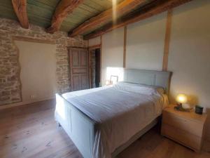 een slaapkamer met een bed en een houten vloer bij Le Paradis de Nina 