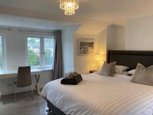 - une chambre avec un grand lit et un sac à dos dans l'établissement Sommersway Cottage, à Brixham