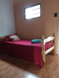 een slaapkamer met een bed met paarse lakens en een raam bij Departamento Fratellino a pasos del Hospital Rossi in La Plata