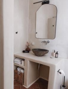 uma casa de banho com um lavatório e um espelho em The Mykonos House - Newly Renovated Villa Near Town em Míconos