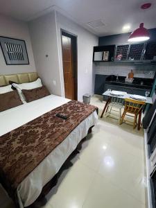 a bedroom with a bed and a table in it at Studio Bangalô Belém Hospedagem in Belém