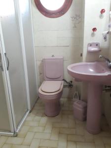 bagno con servizi igienici rosa e lavandino di SEFERİHİSAR ÜRKMEZ DE KİRALIK YAZLIK a Ürkmez