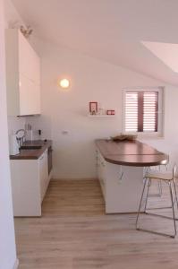 Vila Anda في بروماجنا: مطبخ أبيض مع طاولة ومغسلة