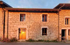 een stenen huis met een gele deur in een straat bij Le Paradis de Nina 