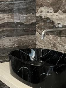 a black bathroom sink with a chrome faucet at Loft Sirmione in Sirmione +37 photos