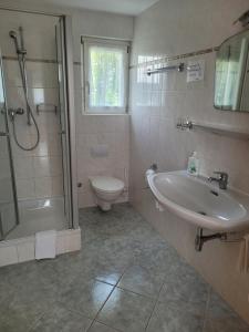 a bathroom with a sink and a shower and a toilet at Gästezimmer Suppan in Hörbranz