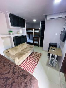 a living room with a couch and a table at Studio Bangalô Belém Hospedagem in Belém