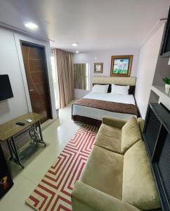 Habitación de hotel con cama y sofá en Studio Bangalô Belém Hospedagem, en Belém