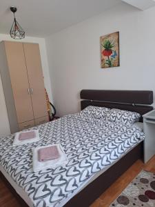 um quarto com uma cama com um edredão preto e branco em Apartman Park em Zvornik