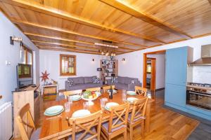 a kitchen and living room with a wooden ceiling at House Andrija in Jasenak