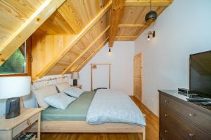 a bedroom with a bed and a flat screen tv at House Andrija in Jasenak