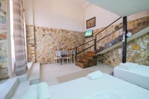 a room with two beds and a dining room with a table at Garden Villa Lake Side & Glamping in Ksamil