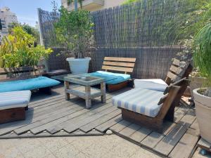 un patio con bancos, mesa y sillas en Indigo roof garden Apt. 1BR 1BA, en Tel Aviv