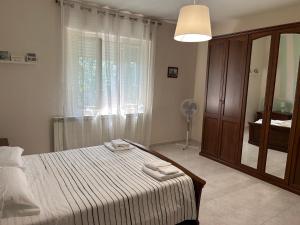 - une chambre avec un lit et une fenêtre avec un ventilateur dans l'établissement Villa GaribaldinA, à Treglio