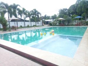 une grande piscine avec de l'eau bleue et des palmiers dans l'établissement RODBON PLACE, à Sara
