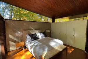 um quarto com uma cama e uma grande janela em 1956 Award Masterpiece .Easy conmute to NYC.Nature surrounded . em Rye