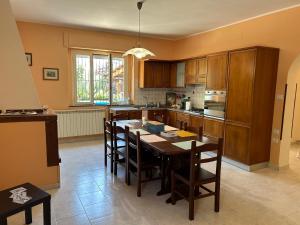 une cuisine avec une grande table et des chaises en bois dans l'établissement Villa GaribaldinA, à Treglio