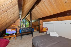 a bedroom with a bed and a tv in a attic at New!!! Dreamy Bear Haus- Updated Retro Retreat & Spa, Pet & Kid Friendly in Big Bear Lake