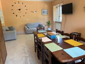 - un salon avec une table, des chaises et une horloge dans l'établissement Villa GaribaldinA, à Treglio