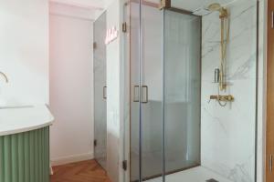 a shower with a glass door in a bathroom at L’appartement Korzó in Satu Mare