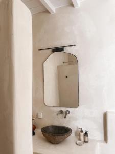 米克諾斯城的住宿－The Mykonos House - Newly Renovated Villa Near Town，一间带石制水槽和镜子的浴室