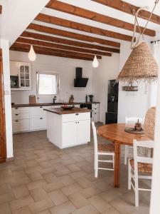 uma cozinha com armários brancos e uma mesa de madeira em The Mykonos House - Newly Renovated Villa Near Town em Míconos