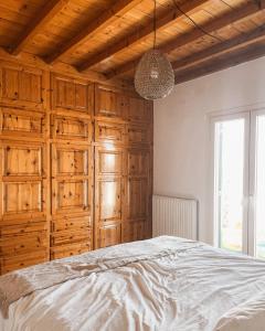 米克諾斯城的住宿－The Mykonos House - Newly Renovated Villa Near Town，一间卧室设有木制橱柜和一张大床